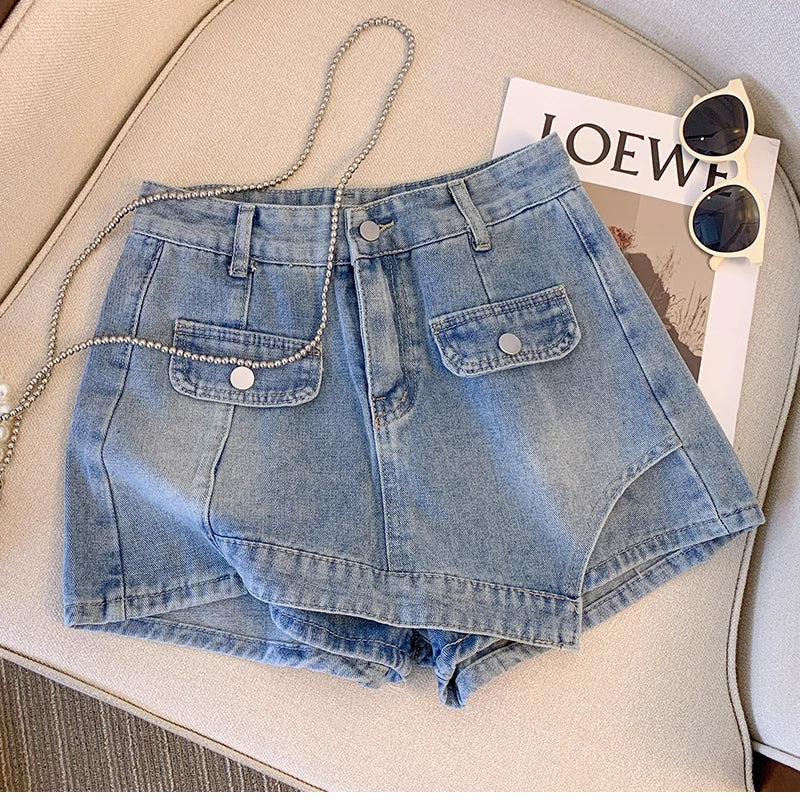 Damen Jeansshorts blau, modisch, mit Taschen, auf Sofa mit Sonnenbrille und Magazin.