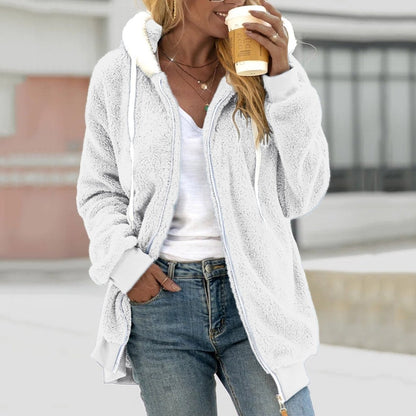 Frau in grauer Teddyweste mit Reißverschluss, hält Kaffeebecher, lässige Mode, Herbstkleidung.