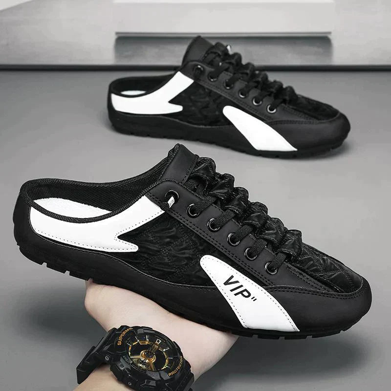 Schwarze und weiße Herren-Sneaker, sportlich, mit VIP-Logo, auf grauem Hintergrund.