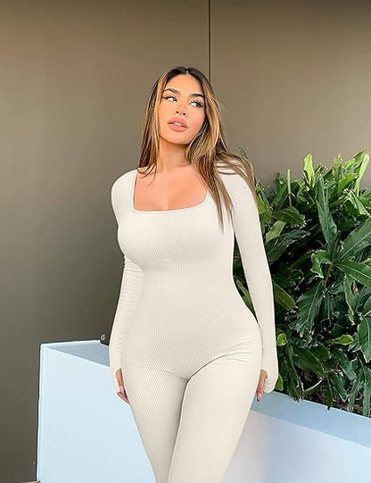Frau in weißem, langärmligem Shapewear-Jumpsuit vor grünen Pflanzen.