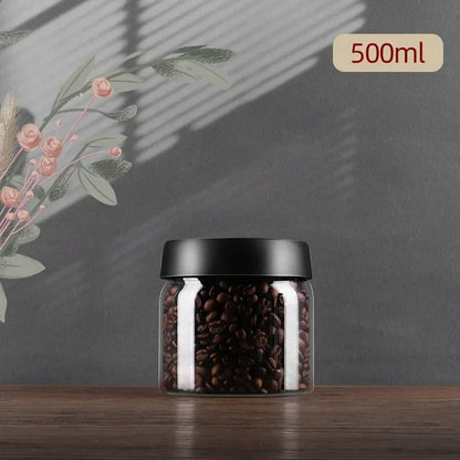 Glasbehälter mit schwarzem Deckel, gefüllt mit Kaffeebohnen, 500ml, auf Holztisch.