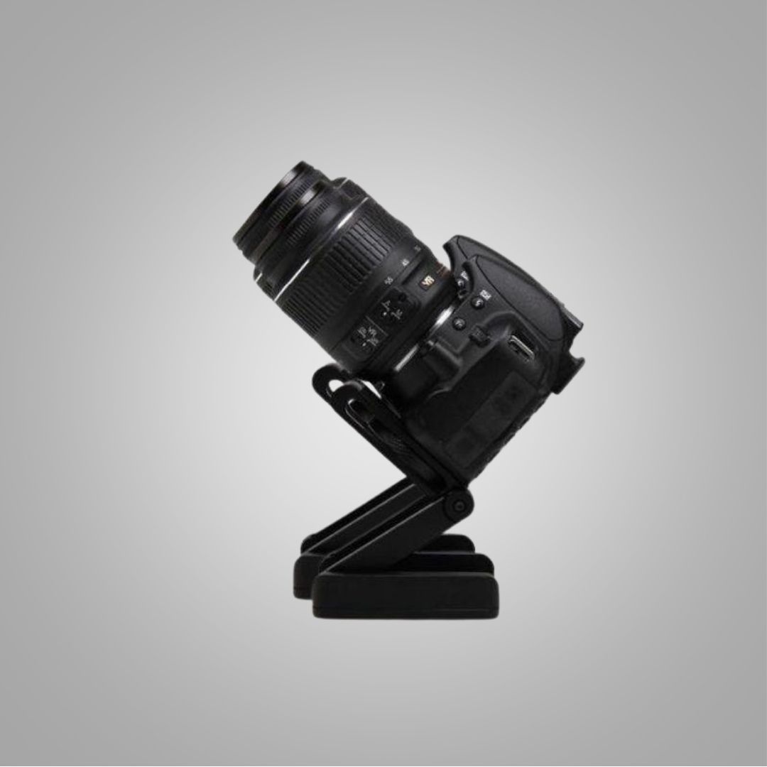 Schwarze DSLR-Kamera auf verstellbarem Stativ, seitliche Ansicht, grauer Hintergrund.