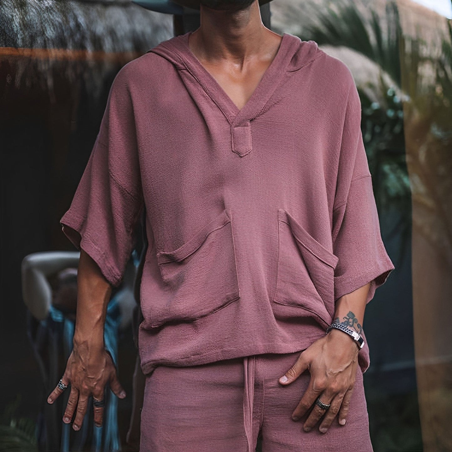 Mann in rosa Kapuzenpullover aus Baumwolle mit kurzen Ärmeln und Taschen, lässiger Stil.