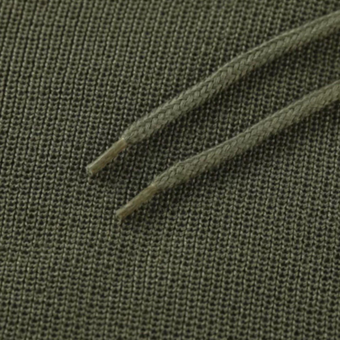 Grüner Baumwollstoff mit Kordelzug, Nahaufnahme, Textilstruktur, Mode, Bekleidungsmaterial.