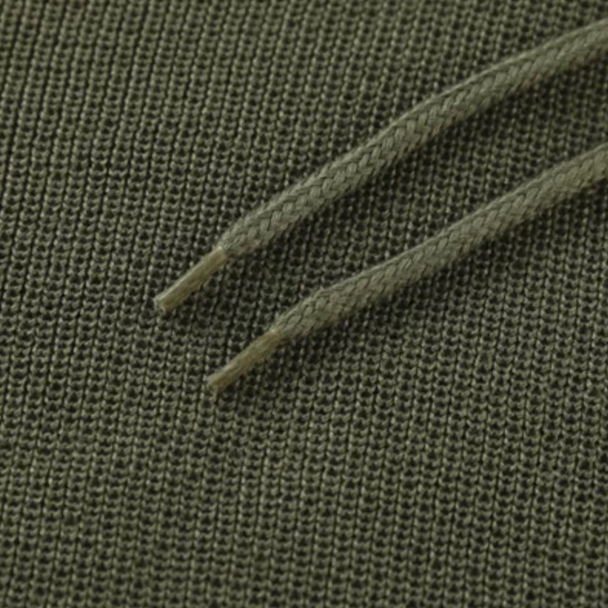 Grüner Baumwollstoff mit Kordelzug, Nahaufnahme, Textilstruktur, Mode, Bekleidungsmaterial.