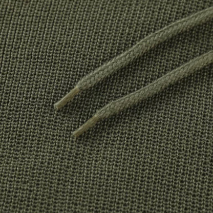 Grüner Baumwollstoff mit Kordelzug, Nahaufnahme, Textilstruktur, Mode, Bekleidungsmaterial.