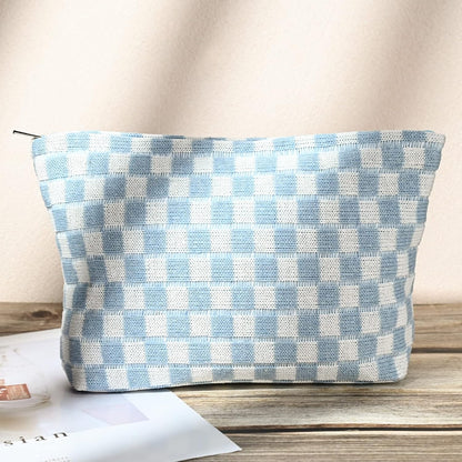 Hellblau-weiß karierte Kosmetiktasche aus Stoff auf Holztisch, stilvoll und praktisch.