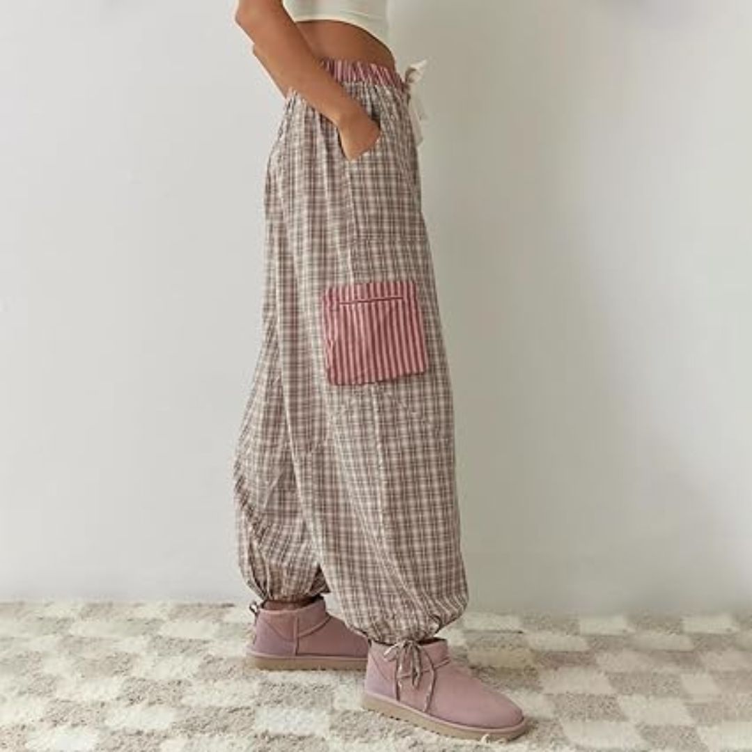Frau in karierten Haremshosen mit rosa Tasche, lässige Mode, bequeme Damenbekleidung.