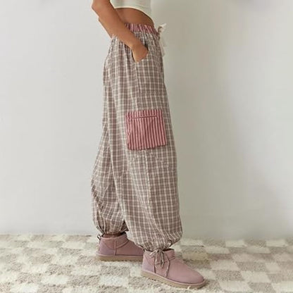 Frau in karierten Haremshosen mit rosa Tasche, lässige Mode, bequeme Damenbekleidung.