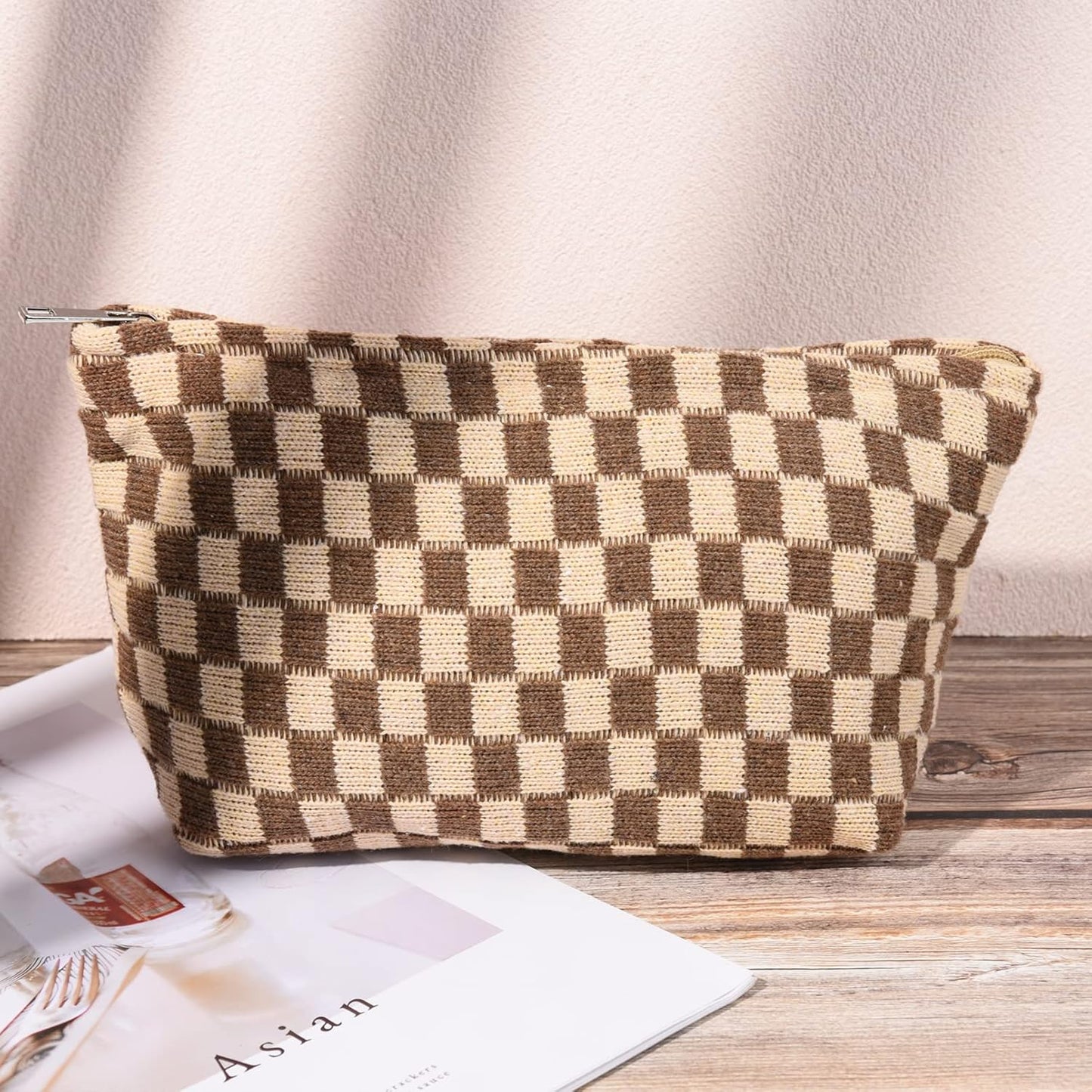 Braune karierte Kosmetiktasche aus Stoff, Reißverschluss, auf Holztisch, stilvoll und praktisch.