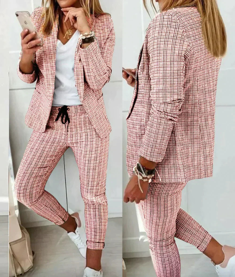 Frau im karierten Anzug, rosa-weiß, mit Smartphone, lässiger Stil, weiße Sneaker.