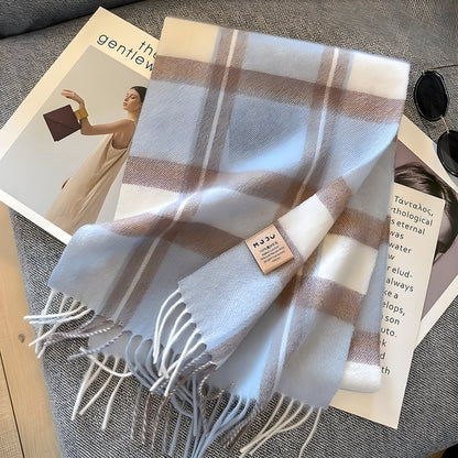Kariertes Kaschmirschal in Weiß und Beige auf grauem Sofa, modisches Accessoire.