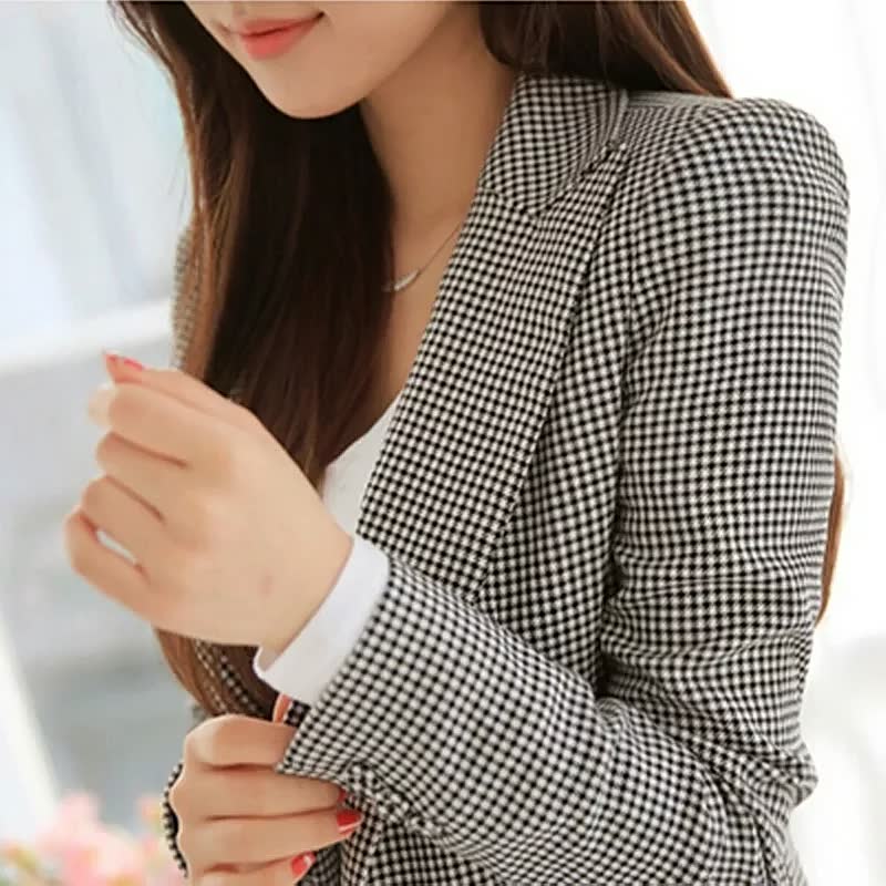 Frau im karierten Blazer, schwarz-weiß, Businessmode, eleganter Look, Damenbekleidung.