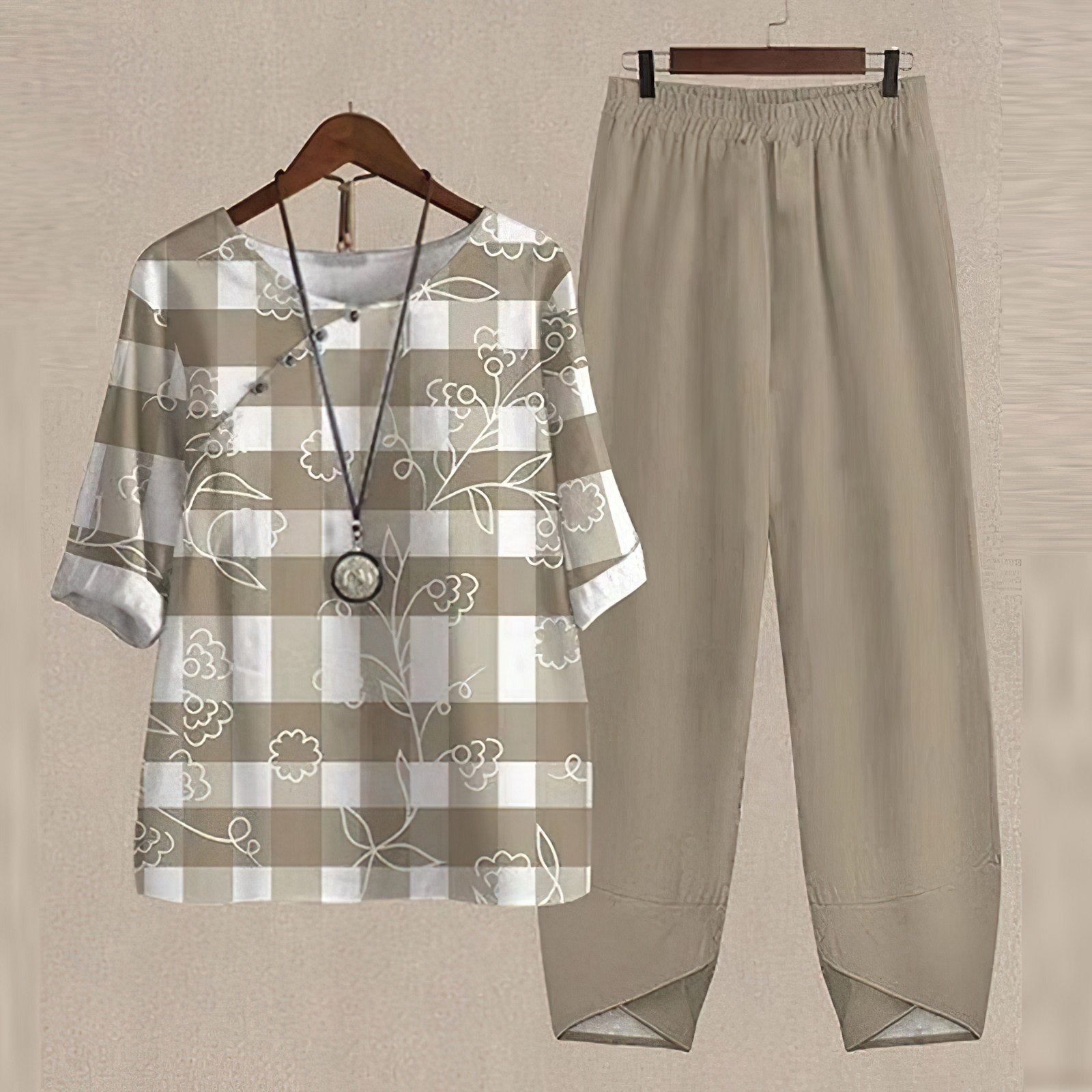 Beige Damen-Outfit, kariertes Oberteil mit Blumenmuster, passende Hose, lässiger Stil.