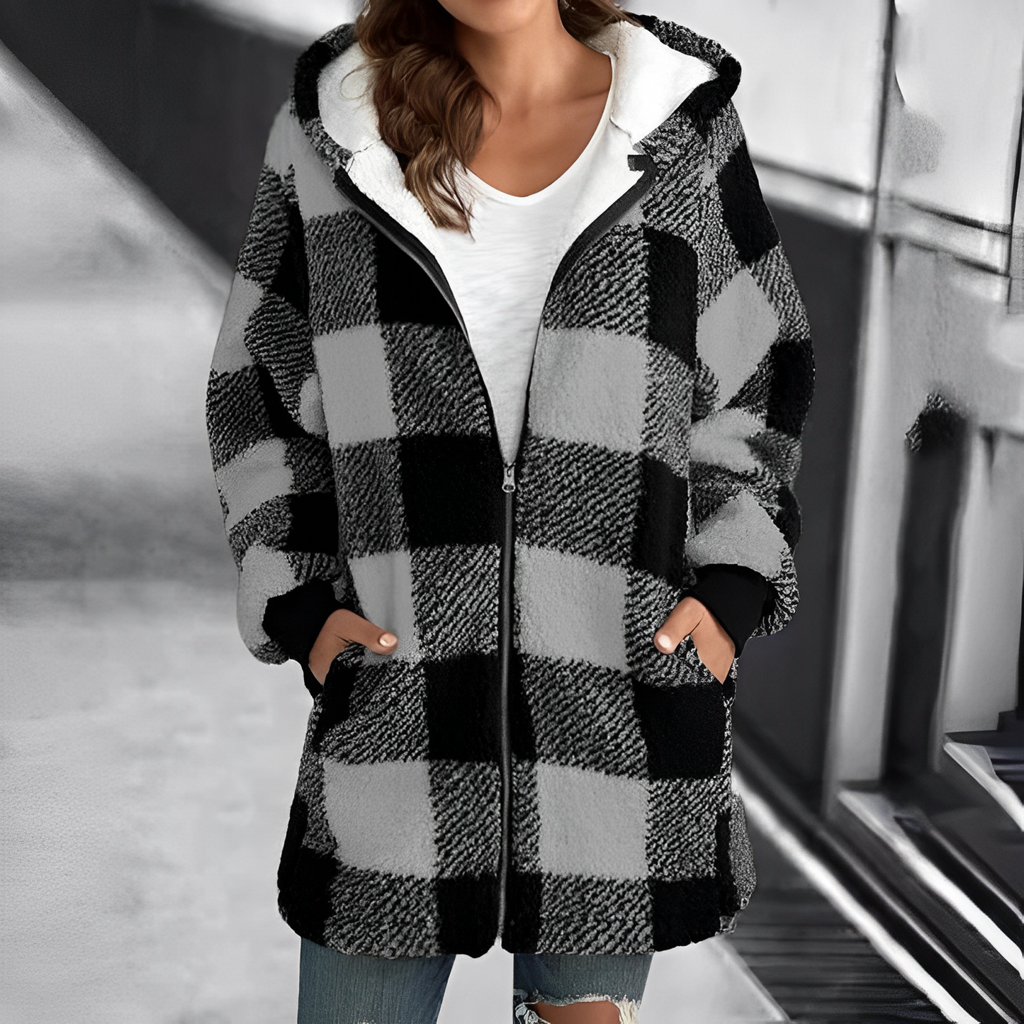Frau in kariertem Wintermantel mit Kapuze, schwarz-weiß, warm, modisch, draußen.