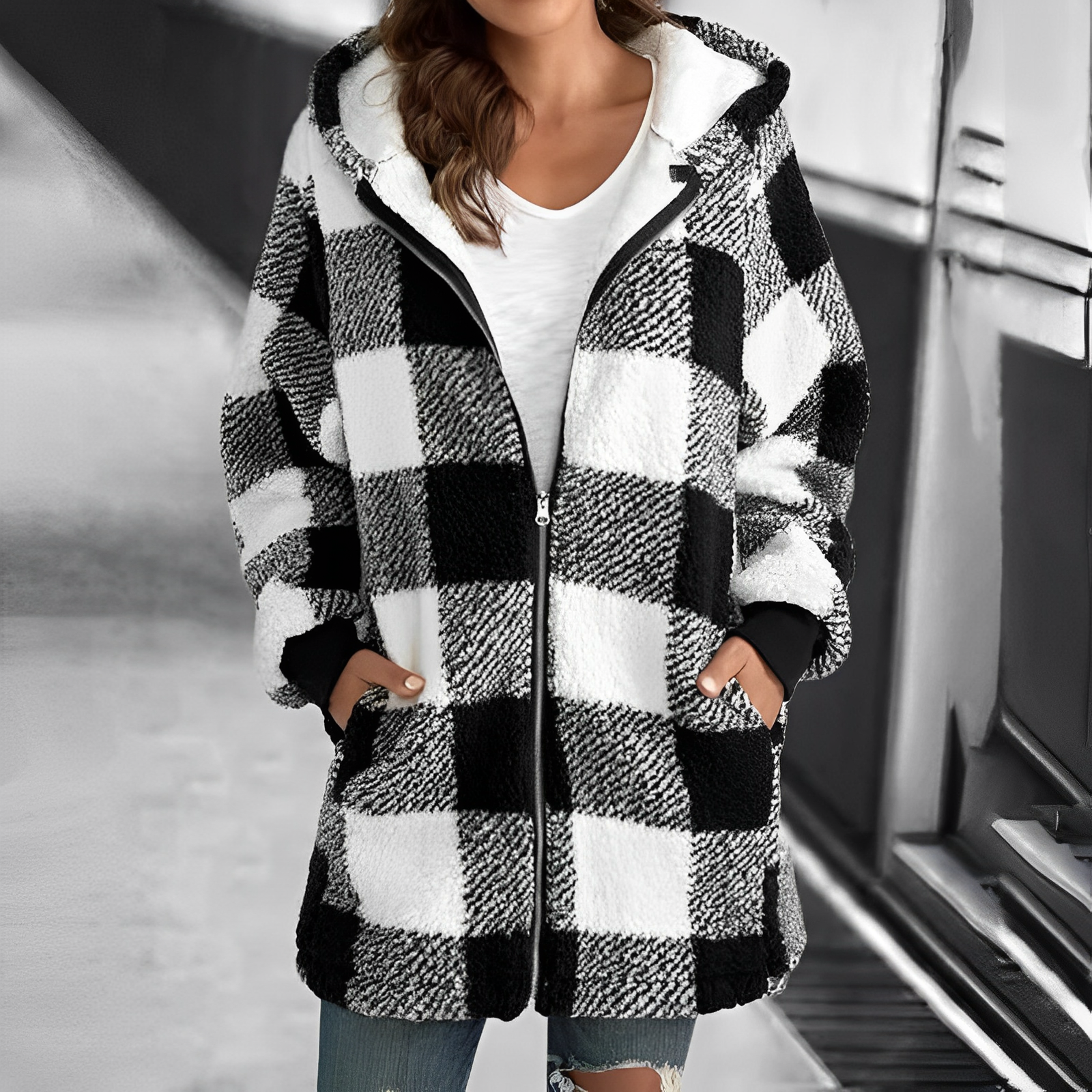 Frau in kariertem schwarz-weißem Fleece-Mantel mit Kapuze, Reißverschluss, Taschen, lässiger Stil.
