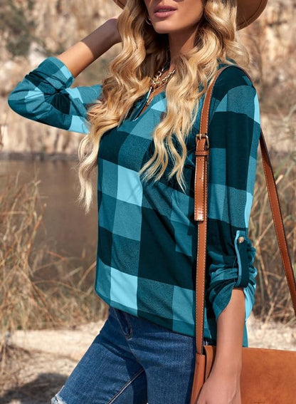 Frau in blau-kariertem Hemd, Jeans und brauner Tasche im Freien, modischer Herbstlook.