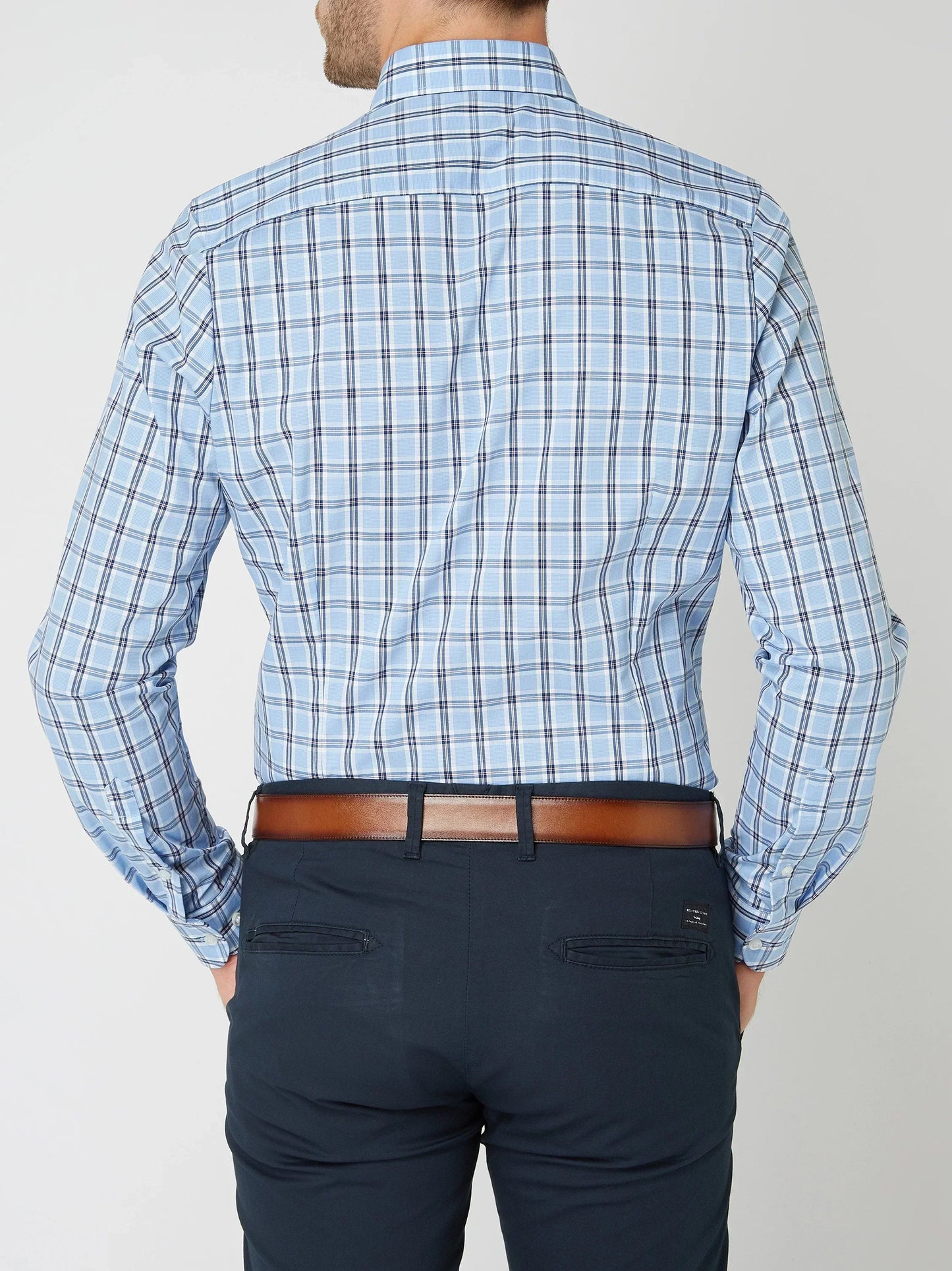 Mann in blau kariertem Hemd und dunkler Hose, Rückansicht, Business-Look, Herrenmode.