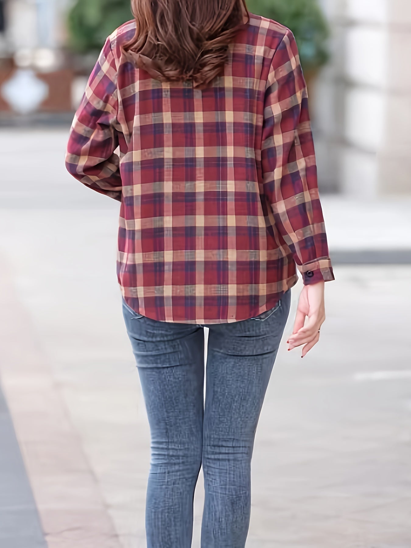 Frau in karierter Bluse und Jeans von hinten, lässige Mode, Herbstoutfit, Straße.