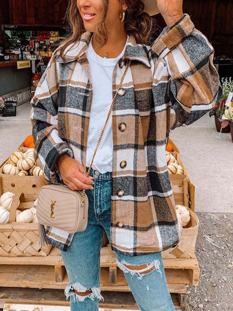Frau in kariertem Flanellhemd, Jeans, beige Tasche, Herbstmarkt, Kürbisse im Hintergrund.