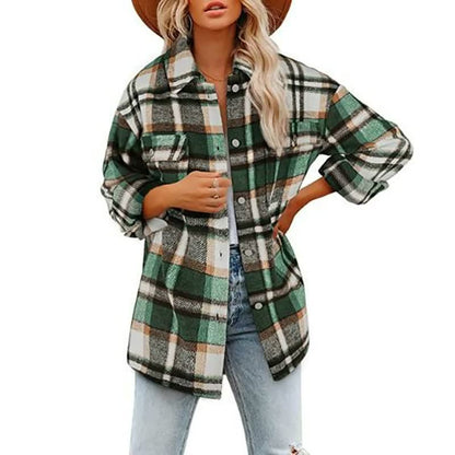 Frau in grün-kariertem Oversize-Hemd, Jeans und Hut, modischer Herbst-Look.