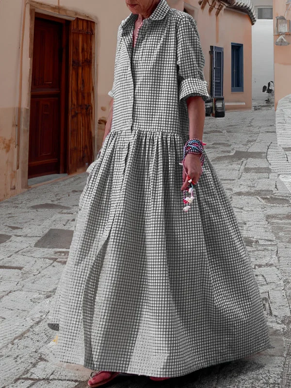 Frau im karierten Maxikleid auf gepflasterter Straße, Sommermode, Freizeitkleidung.