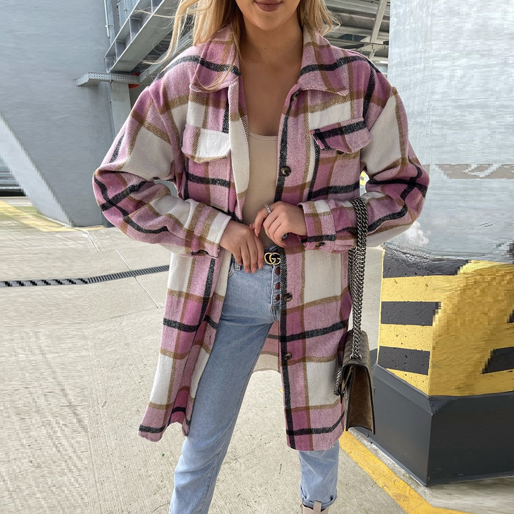 Frau trägt karierte Oversize-Jacke in Rosa und Weiß, kombiniert mit Jeans und beiger Tasche.