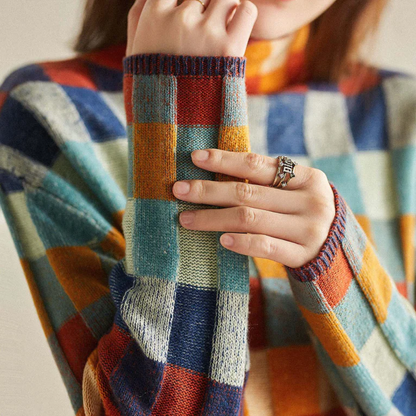 Frau in kariertem Pullover aus Wolle, hält Hand mit Ring, bunte Herbstmode, Nahaufnahme.
