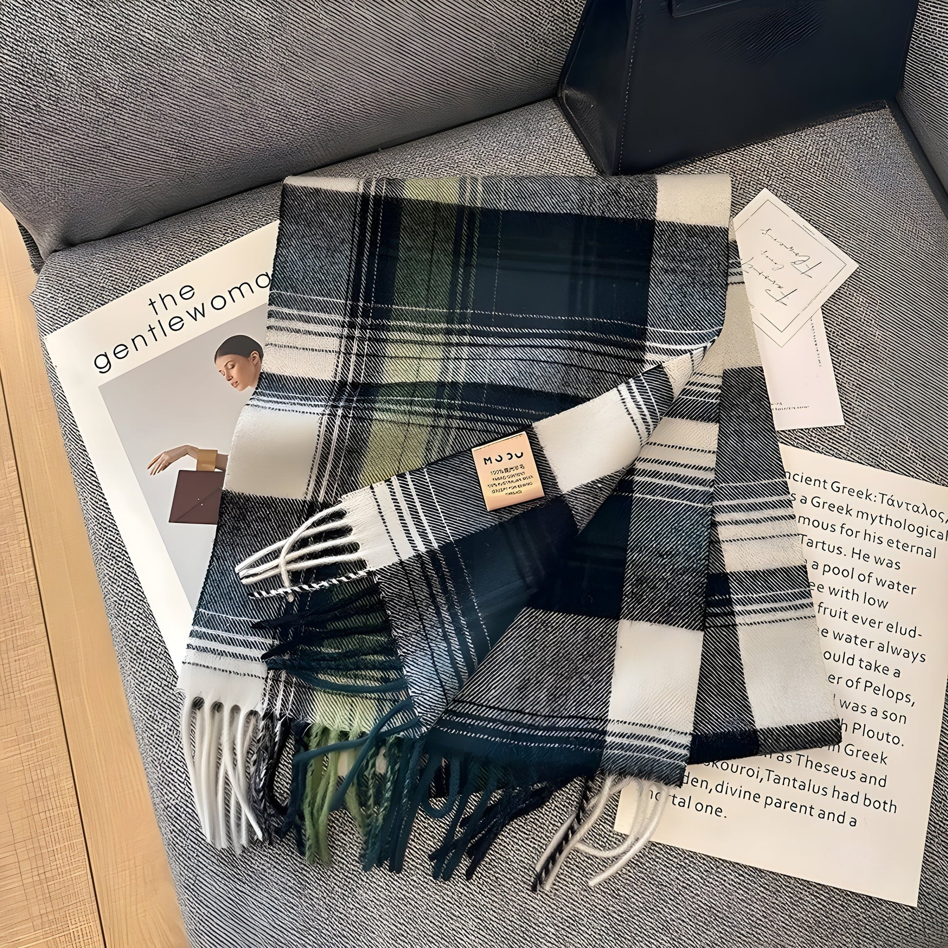Kariertes Wollschal in Grün und Weiß auf grauem Sofa, modisches Accessoire, Herbst-Winter.