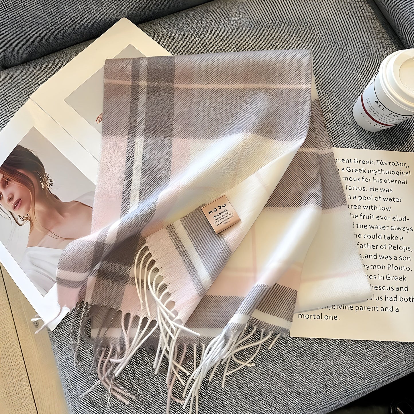 Kariertes, rosafarbenes Kaschmirschal auf Tisch mit Zeitschrift und Kaffeetasse.