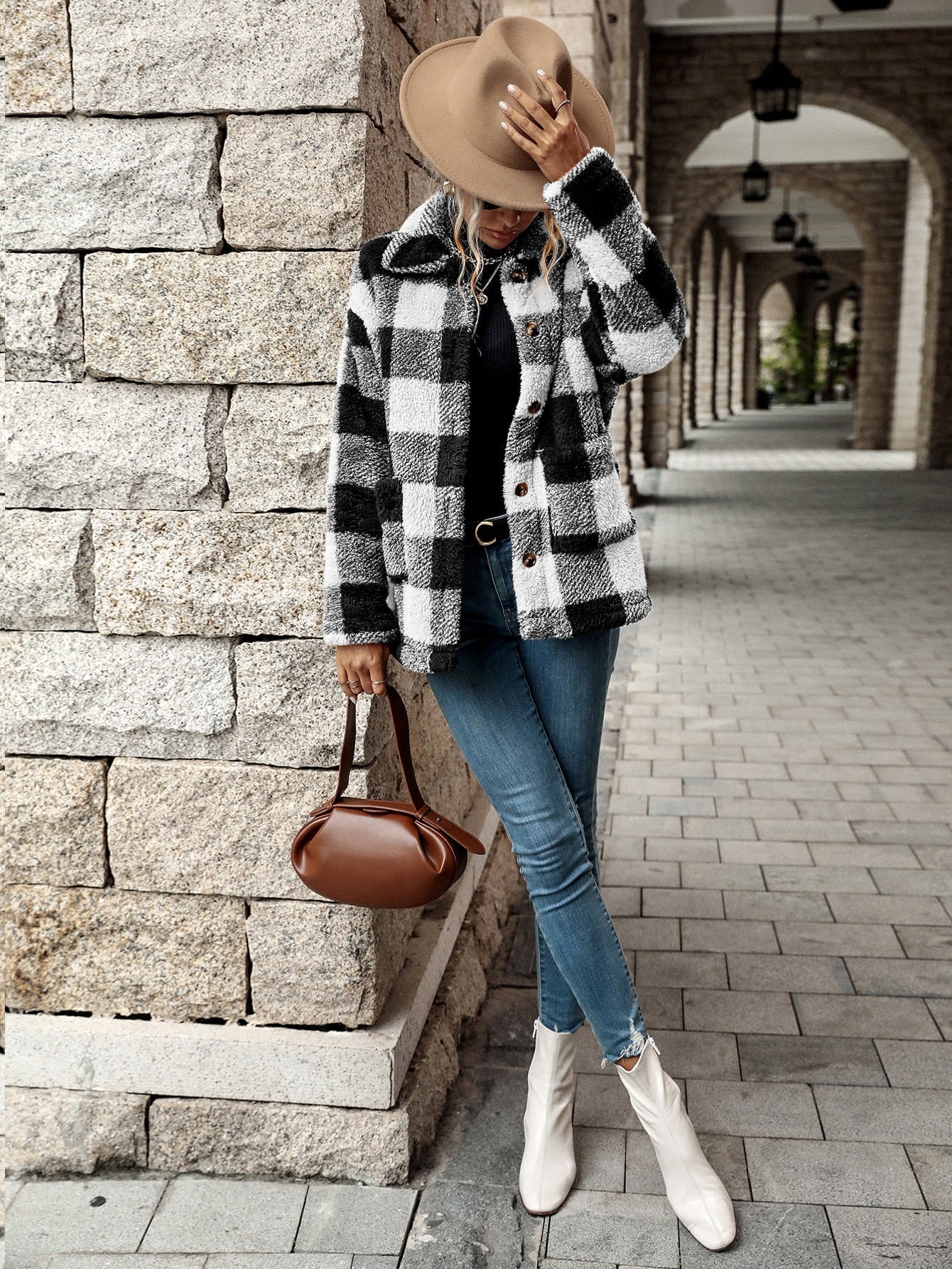Frau in kariertem Mantel, Jeans, weißen Stiefeln, brauner Hut, Handtasche, Herbstmode.