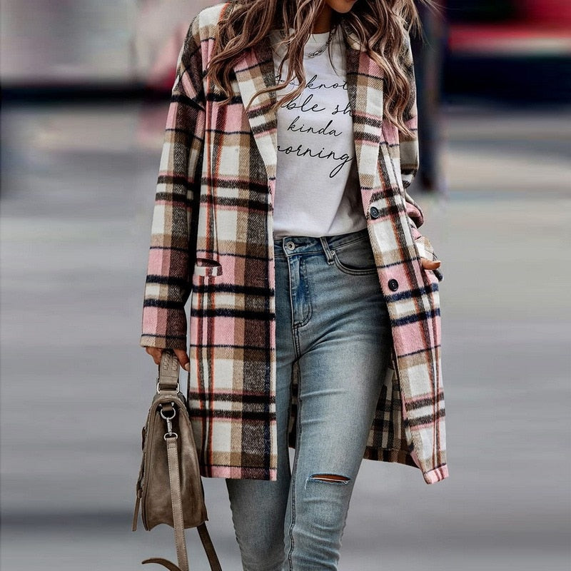 Frau in kariertem Mantel, rosa und braun, mit Jeans und Tasche, modischer Herbstlook.