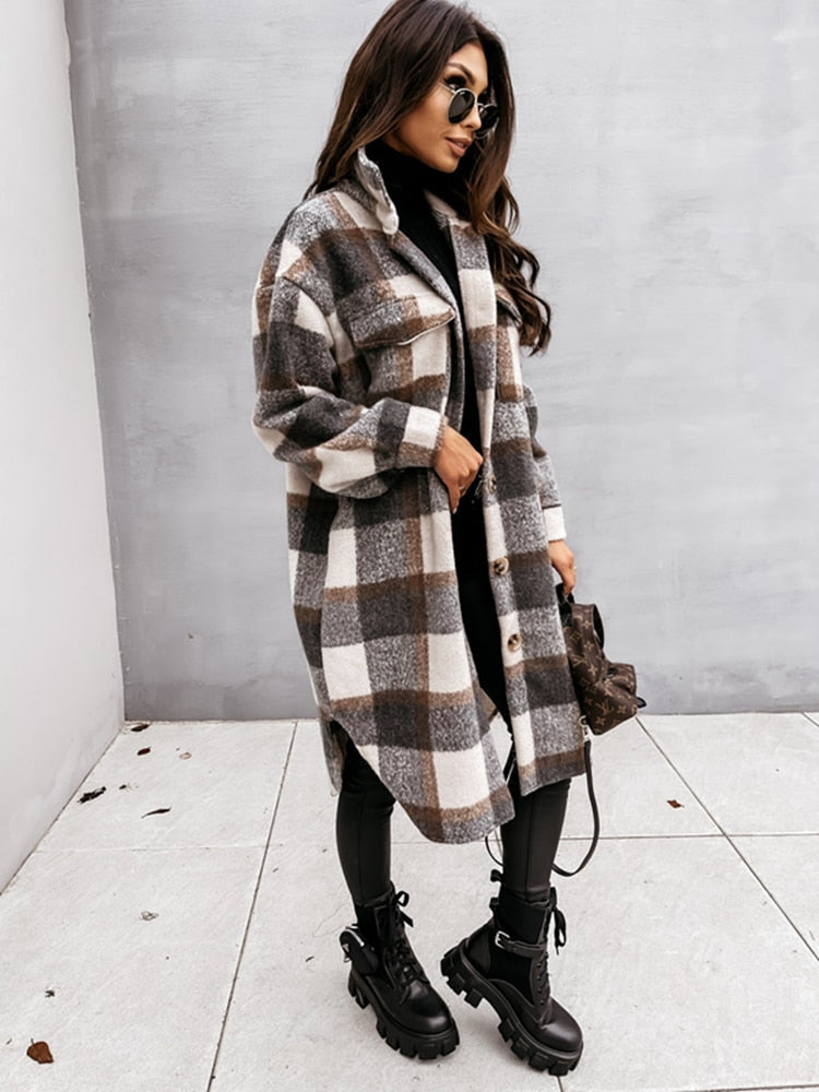 Frau in kariertem Oversize-Mantel, schwarze Stiefel, Sonnenbrille, modischer Herbst-Look.