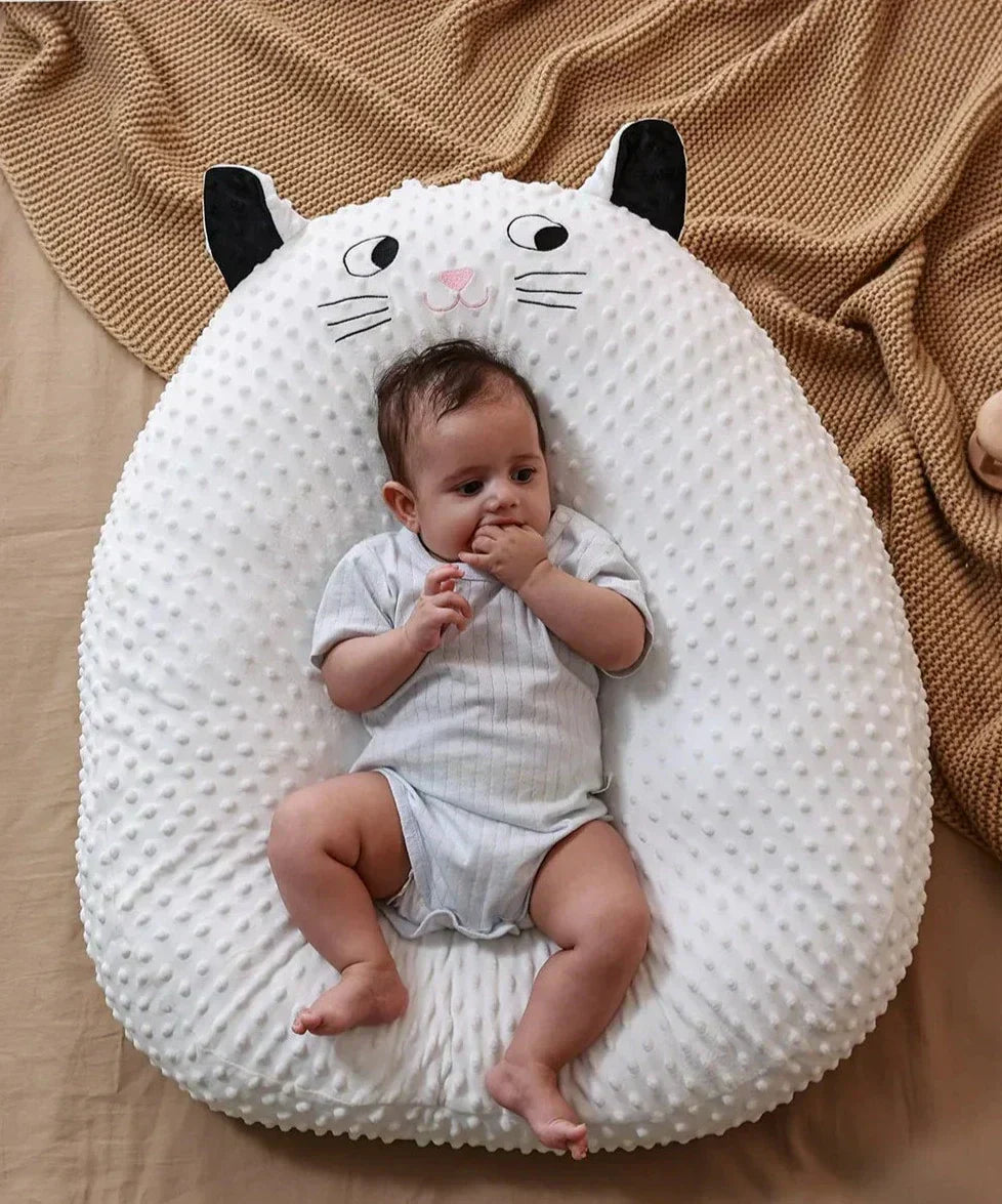 Baby auf weißem Katzen-Babykissen, weicher Stoff, gemütlich, ideal für Neugeborene.