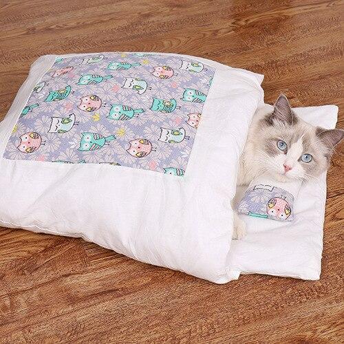 Katze in weißem Bett mit buntem Katzenmuster, Holzfußboden, Haustierbett, gemütlich, niedlich.