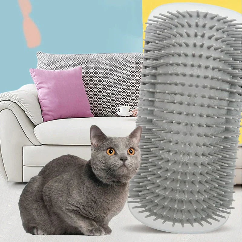 Graue Katzenbürste mit Noppen, ideal für Fellpflege, vor grauer Katze und Sofa.