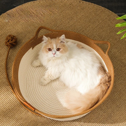 Flauschige Katze in rundem, braunem Katzenbett aus Baumwolle auf Juteteppich.