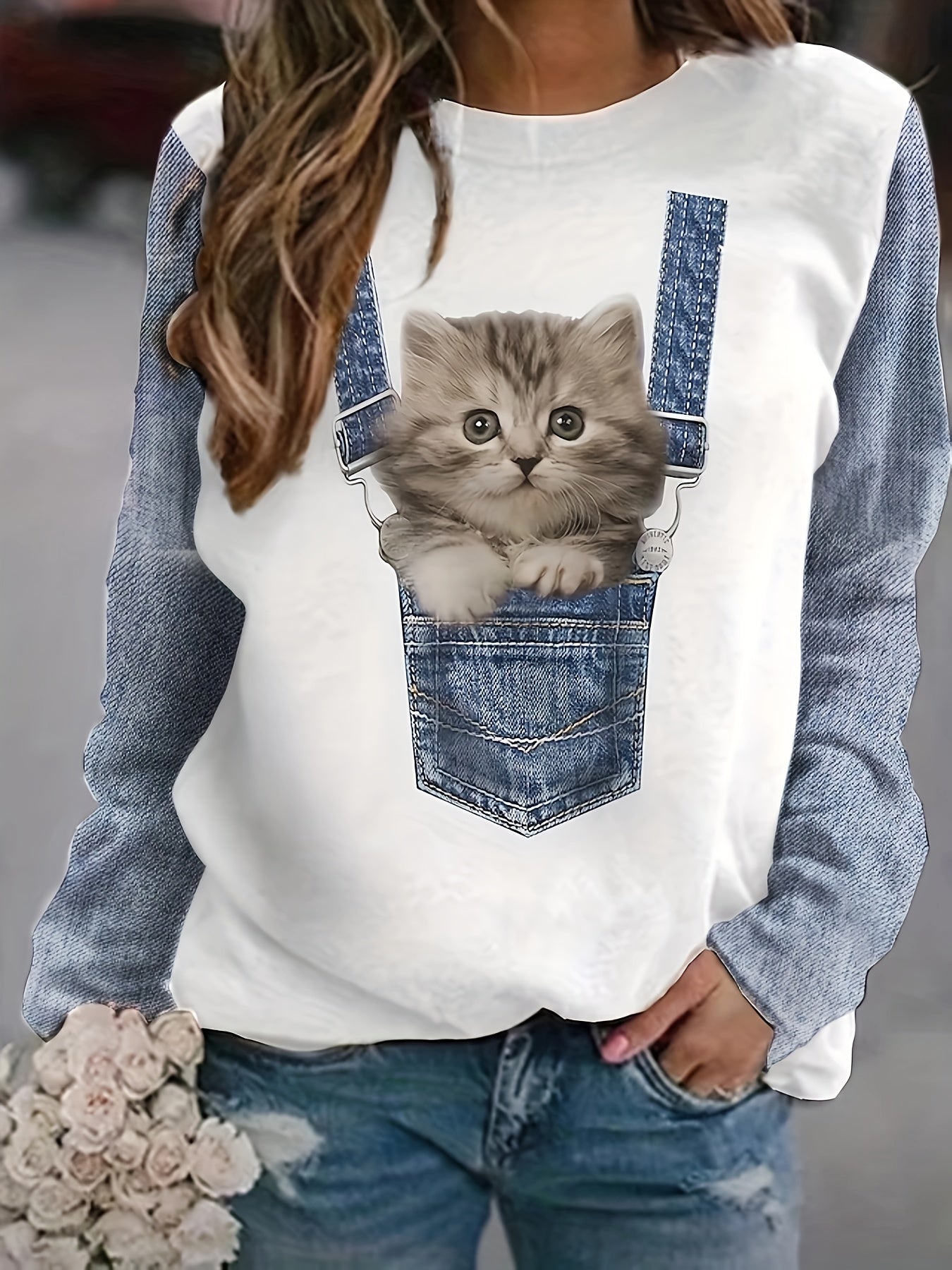 Frau in Jeansjacke mit Katzenmotiv, hält Blumenstrauß, modische Freizeitkleidung.