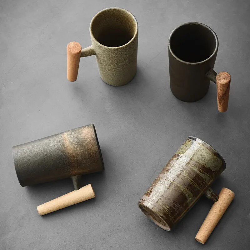 Vier Keramiktassen mit Holzgriffen auf grauem Hintergrund, modern, minimalistisch, stilvoll.