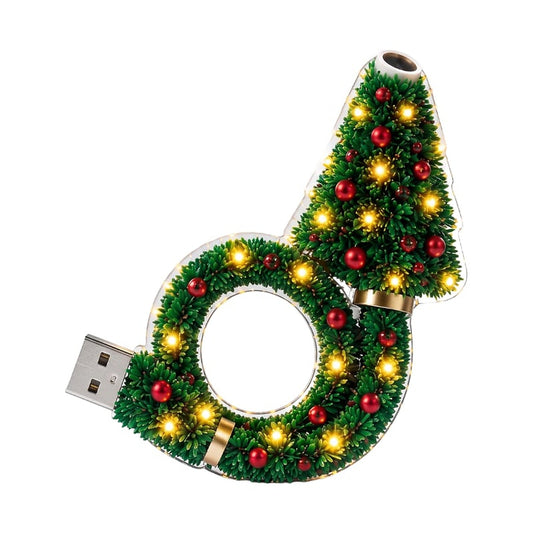 Projektorn fristĂĽende pĂĽ vit bakgrund, med grĂ¶na grenar, rĂ¶da kulor, varma lysdioder, guldringar och USB-kontakt till vĂ¤nster. 1