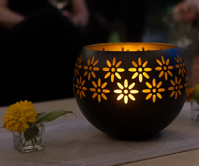Schwarze Metall-Laterne mit Blumenmuster, leuchtend, dekorativ, Tischdekoration, Abendstimmung.