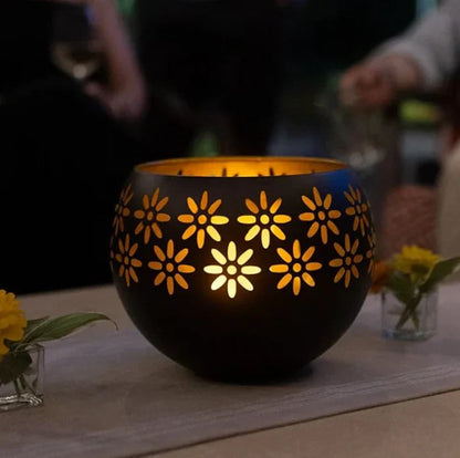 Schwarze Metall-Laterne mit Blumenmuster, leuchtend, Tischdekoration, stimmungsvolles Licht.