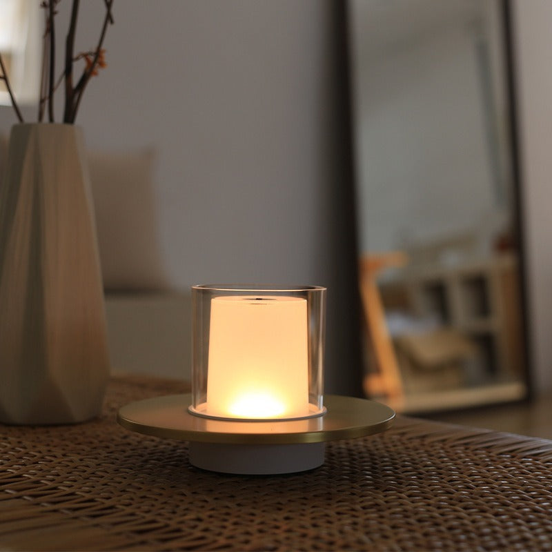 Moderne LED-Kerze auf Holztisch, warmes Licht, Glaszylinder, gemütliche Wohnatmosphäre.