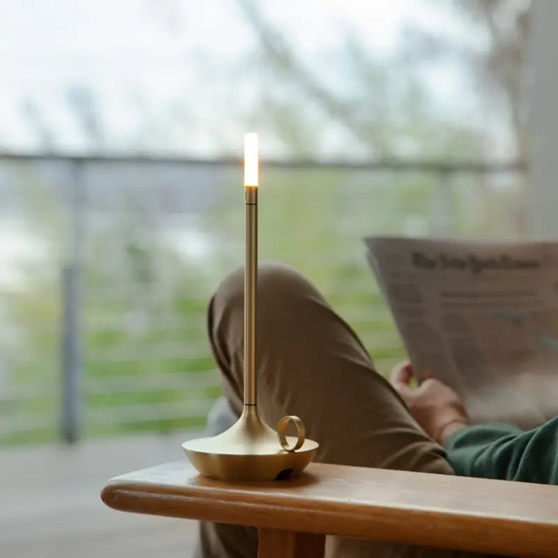 Goldene LED-Kerzenlampe auf Tisch, modernes Design, energiesparend, für Wohnzimmerbeleuchtung.