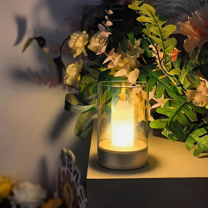 LED-Kerze im Glaszylinder, umgeben von künstlichen Blumen, stimmungsvolle Beleuchtung, Dekoration.