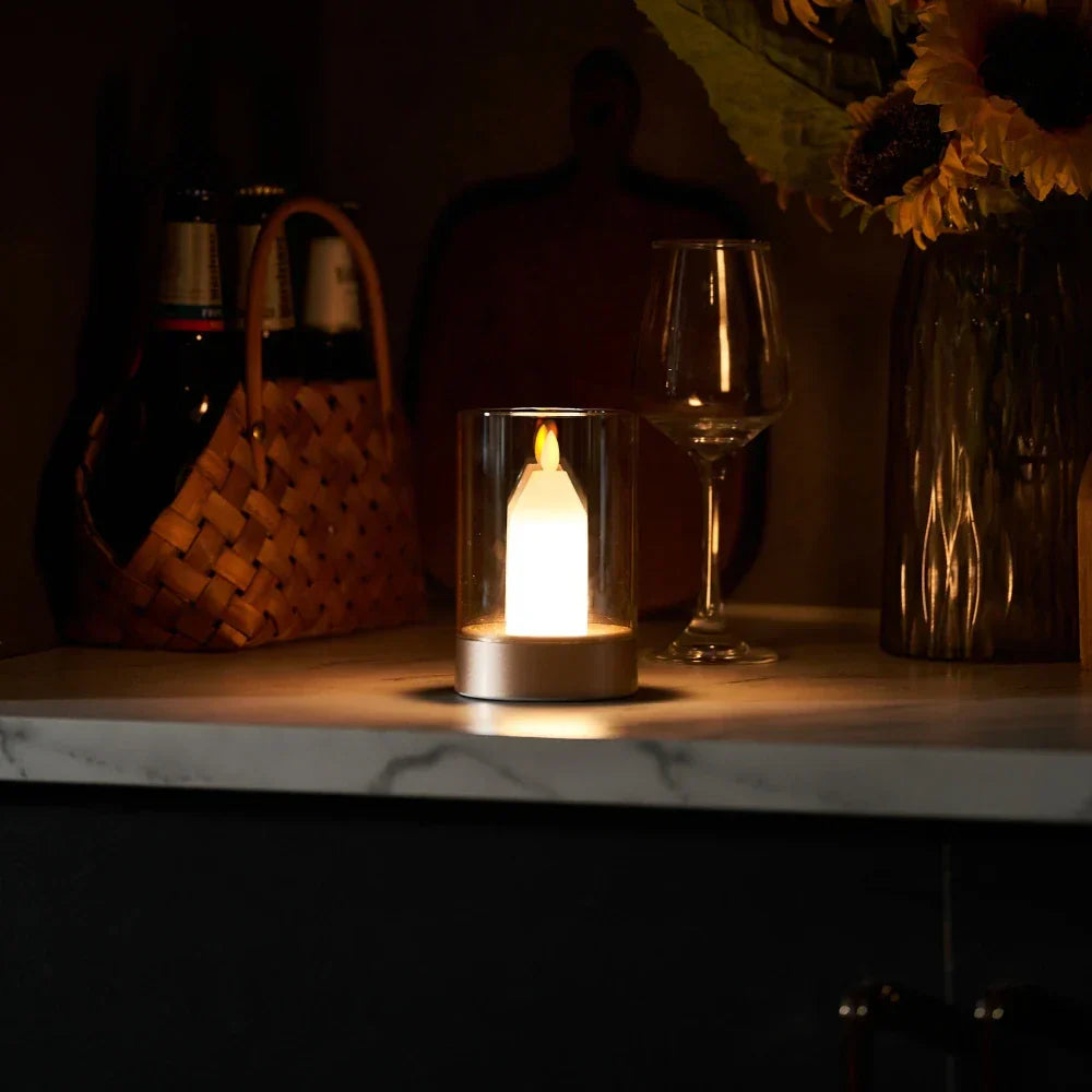 LED-Kerze in Glaszylinder auf Marmortisch, stimmungsvolle Beleuchtung, moderne Dekoration.