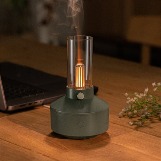 Aromatherapie-Diffuser mit Kerzenlicht, dunkelgrün, Glaszylinder, auf Holztisch, stimmungsvolle Beleuchtung.