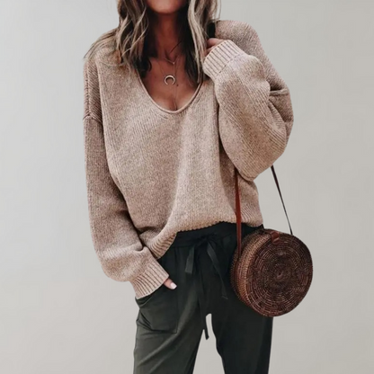 Frau in khaki Pullover und Hose mit runder Strohtasche, lässige Herbstmode.
