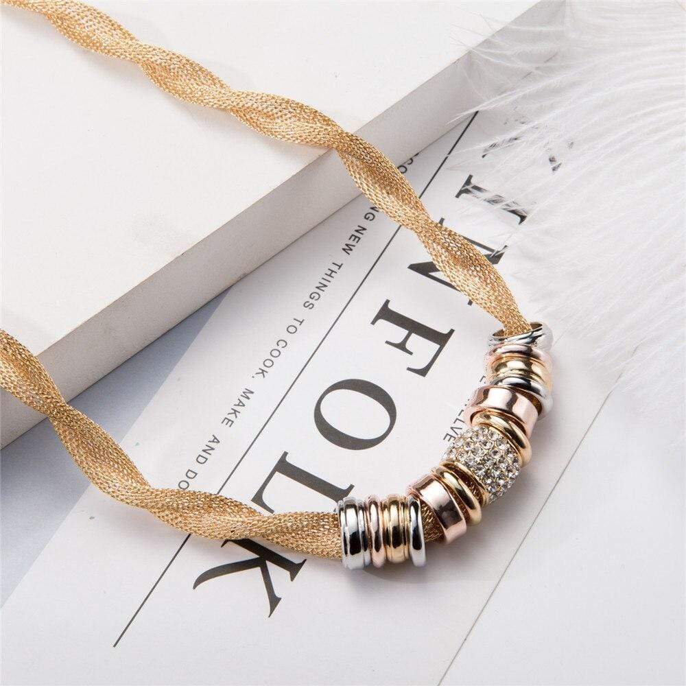 Goldene Halskette mit silbernen und roségoldenen Ringen, modisches Schmuckdesign.