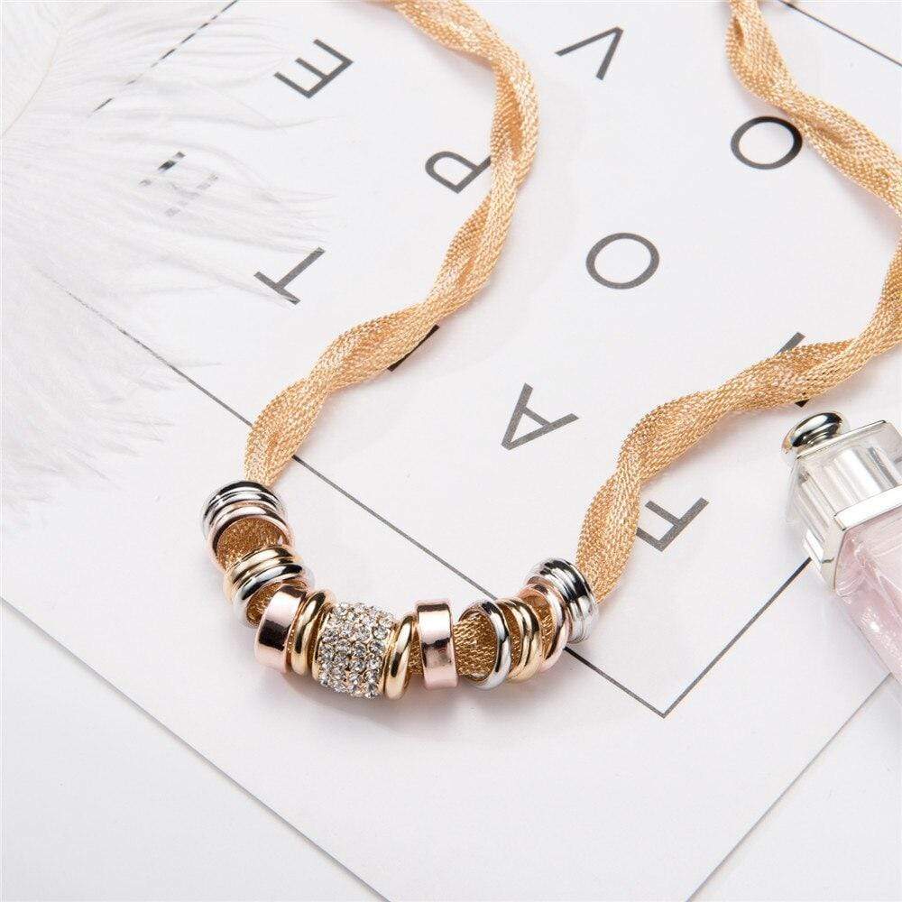 Verflochtene Mode-Halskette, goldfarben, mit dekorativen Ringen, auf weißem Hintergrund.